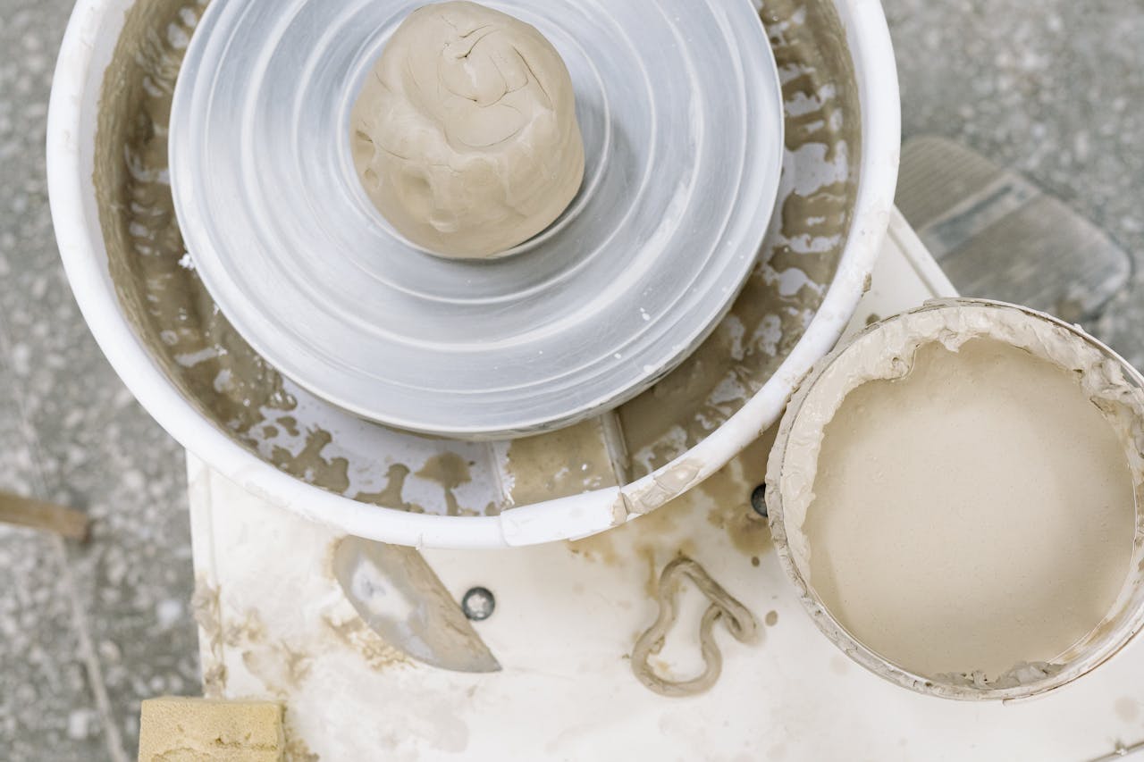 Clay ready on a pottery wheel for shaping, ideal for ceramic art enthusiasts.