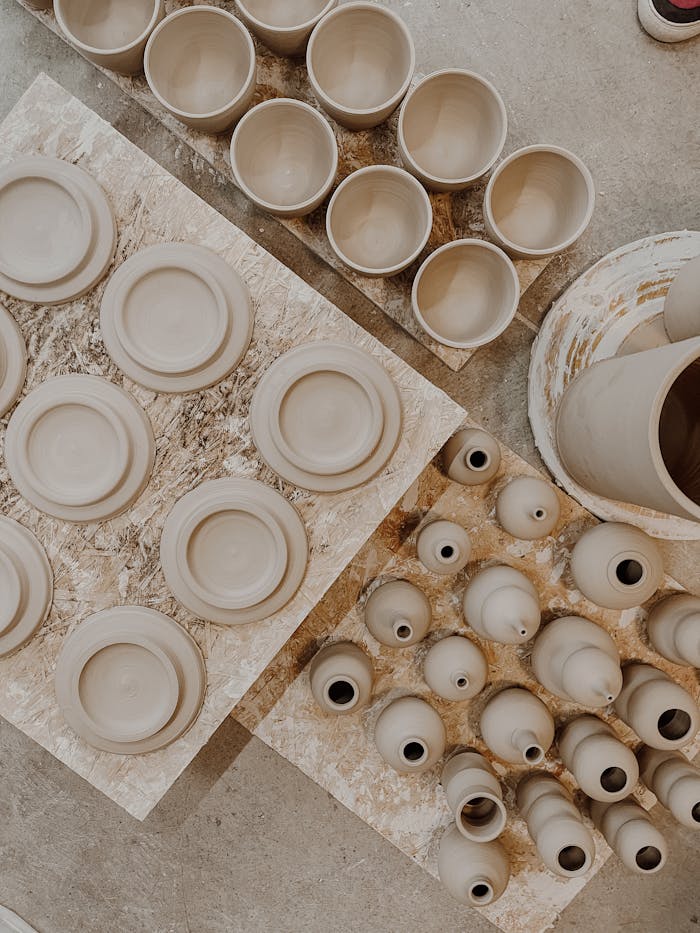 Top view of handcrafted clay pottery arranged on boards, showcasing traditional earthenware crafting.